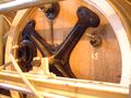 Detail of a cask head. The feeder arm is at the top to fill the casks and allow collapsed fob to return, on the right is the sample tap - only one per side of 13 casks. The flexible tubes run cooling water to the cask attemperators. The iron cross supports the cask on the frame. The cask is clamped into position but released for cleaning by attaching a crank to the trunnion stub.